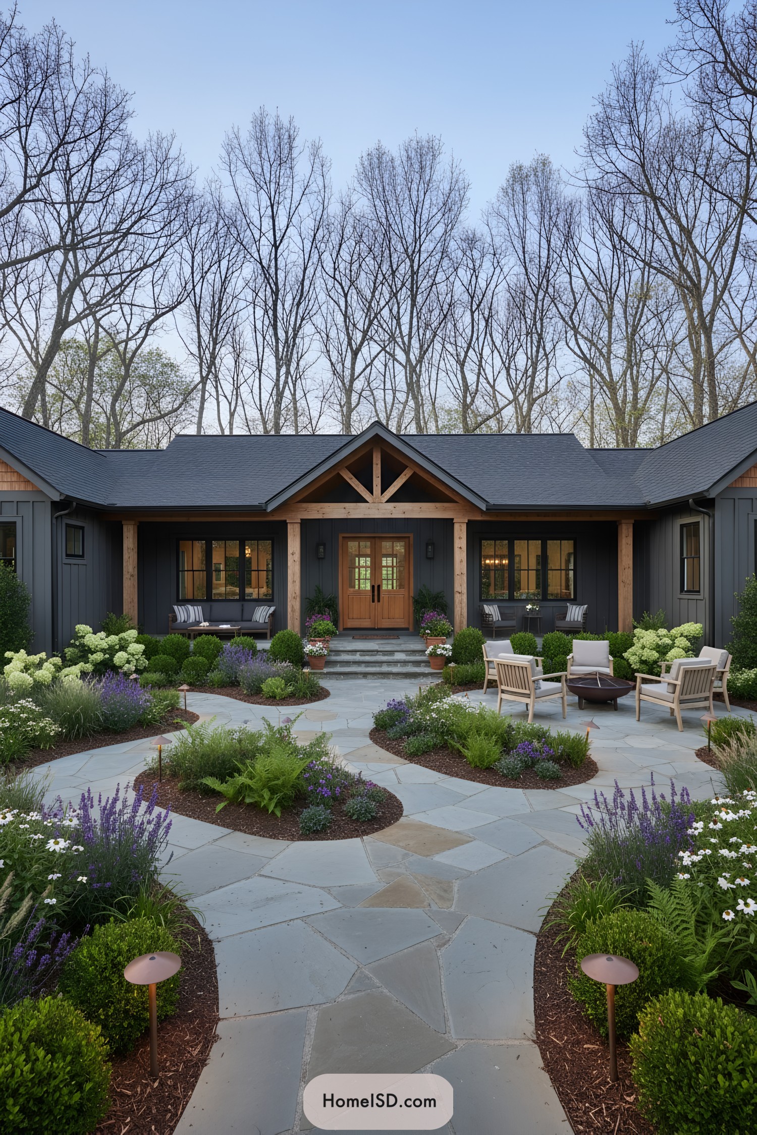 Bluestone courtyard with curved planting beds leading to a dark farmhouse framed by wood beams and cozy seating areas