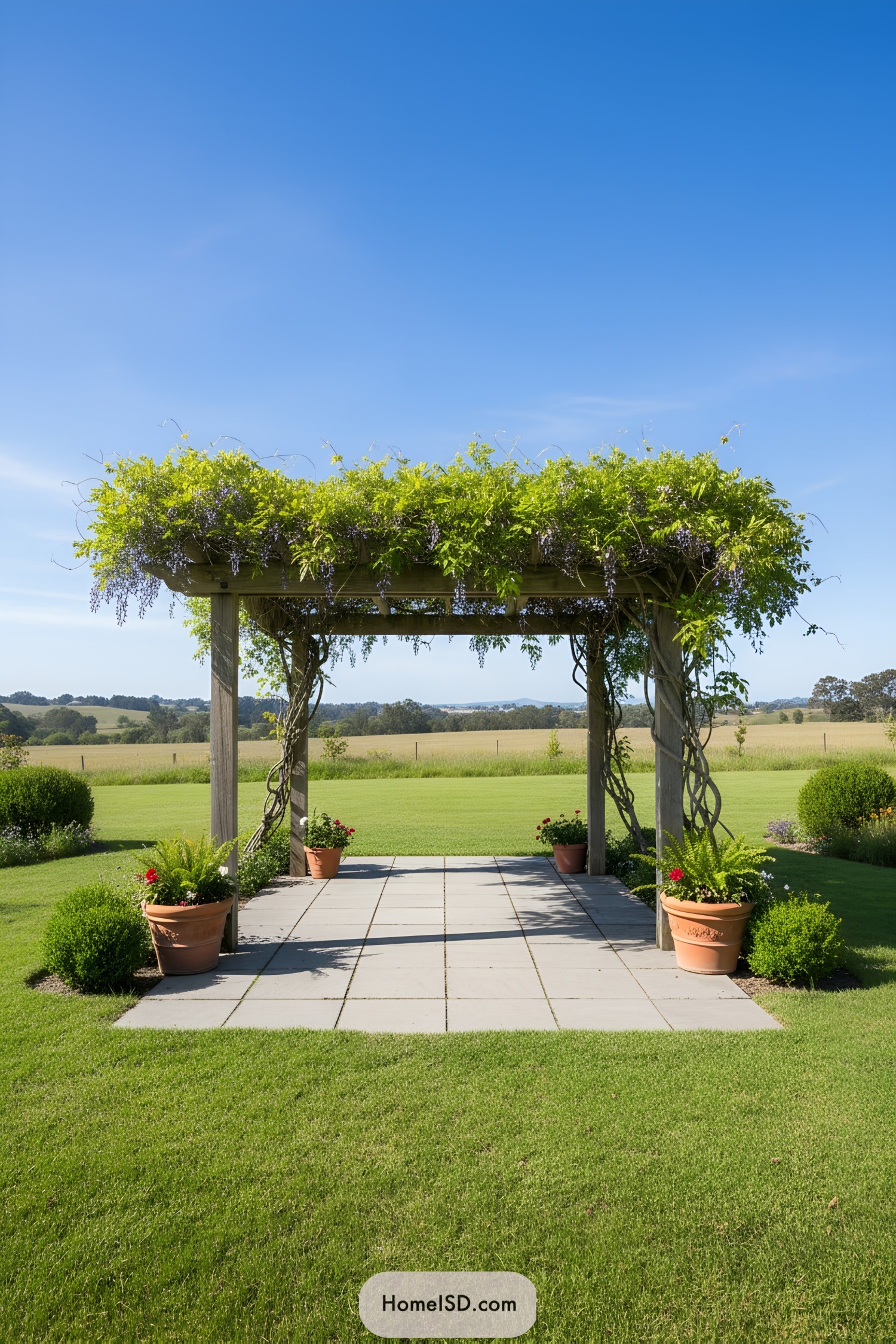 Wooden pergola with leafy vine canopy over a tiled patio in an open lawn