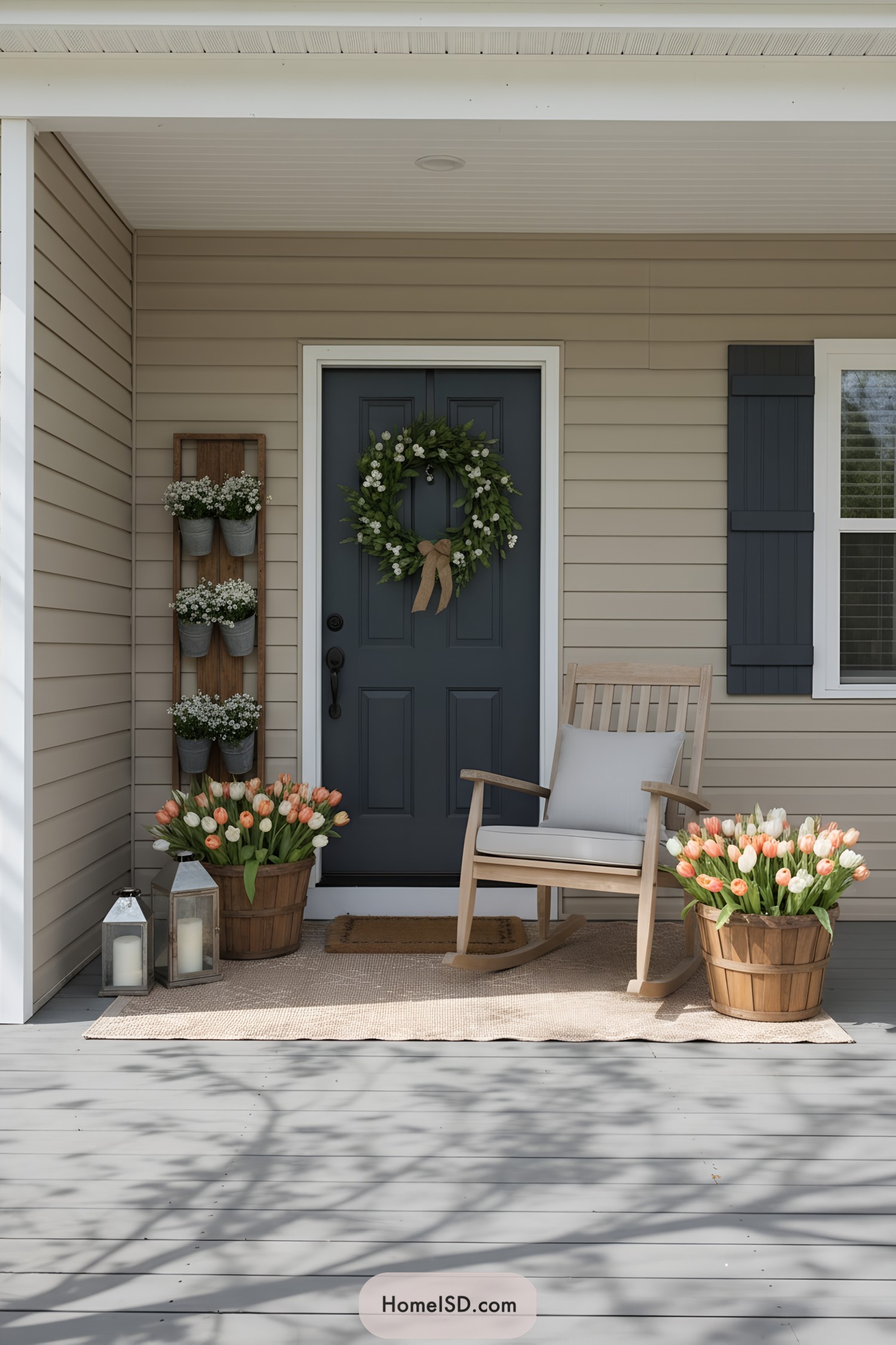 Neutral porch with navy door, rocking chair, and tulip-filled wooden buckets